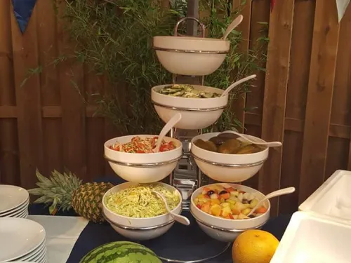 Buffet met fruit en salades onder een feestelijke overkapping met vlaggetjes