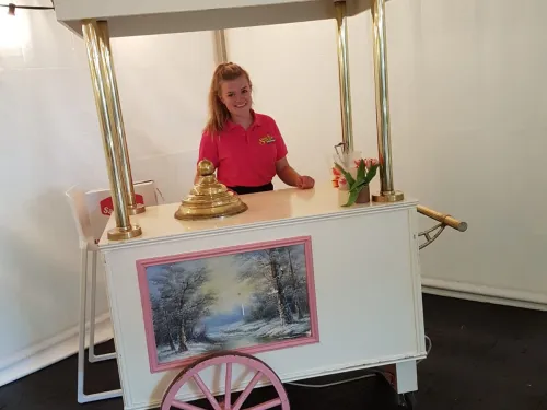 Medewerker achter een witte snoepkar