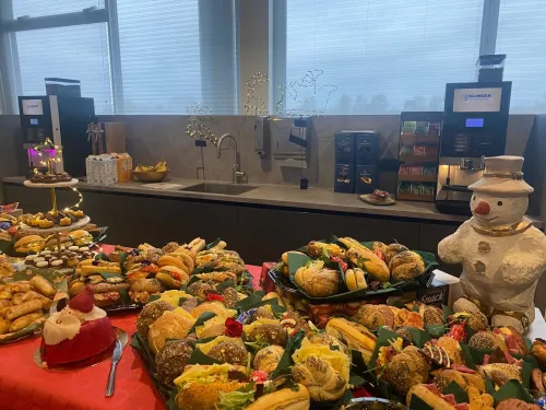 Kerstlunch op kantoor met belegde broodjes, gebak en kerstversiering