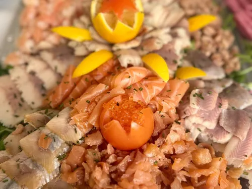 Visschotel met gerookte zalm, paling en makreel, versierd met citroen en tomaat
